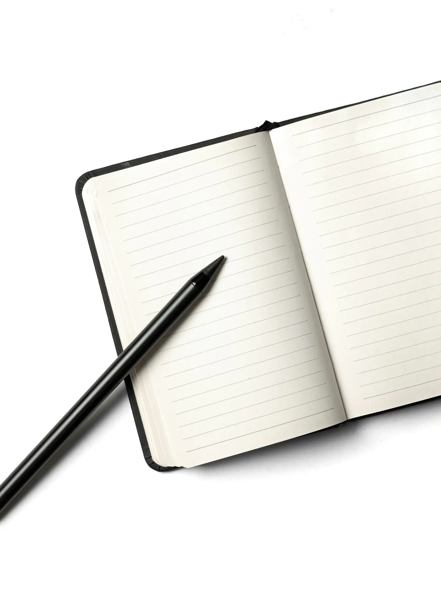 Carnet ligné ouvert et stylo noir sur fond blanc