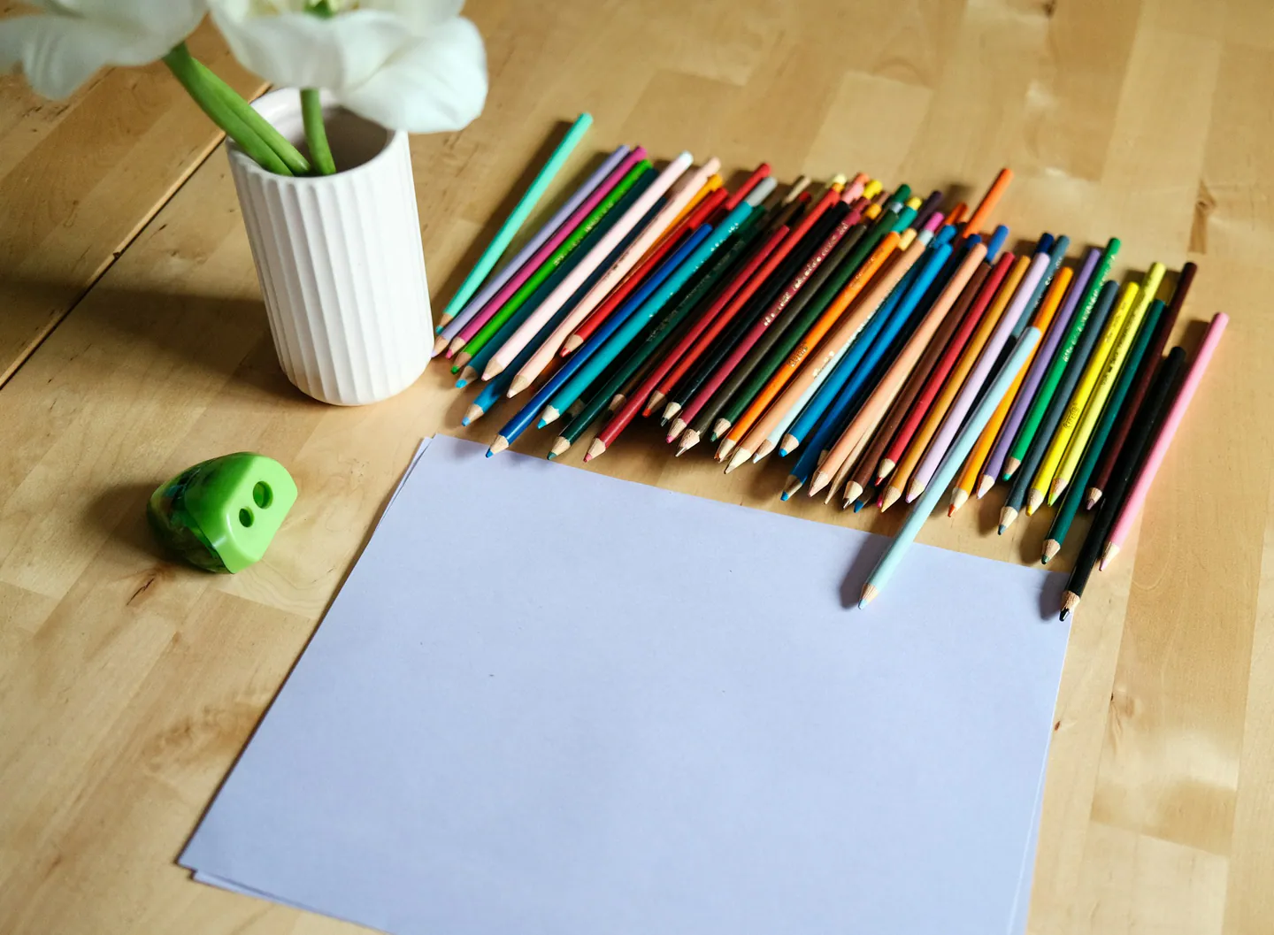 Crayons de couleur et feuille blanche sur une table en bois