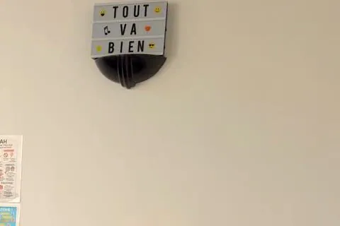 Boite lumineuse Tout va bien accrochee au mur du bureau